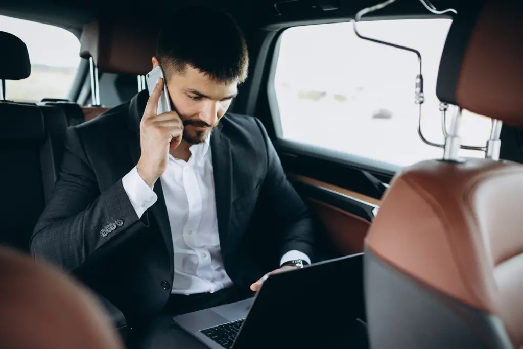handsome-business-man-working-computer-car - limousine service houston texas